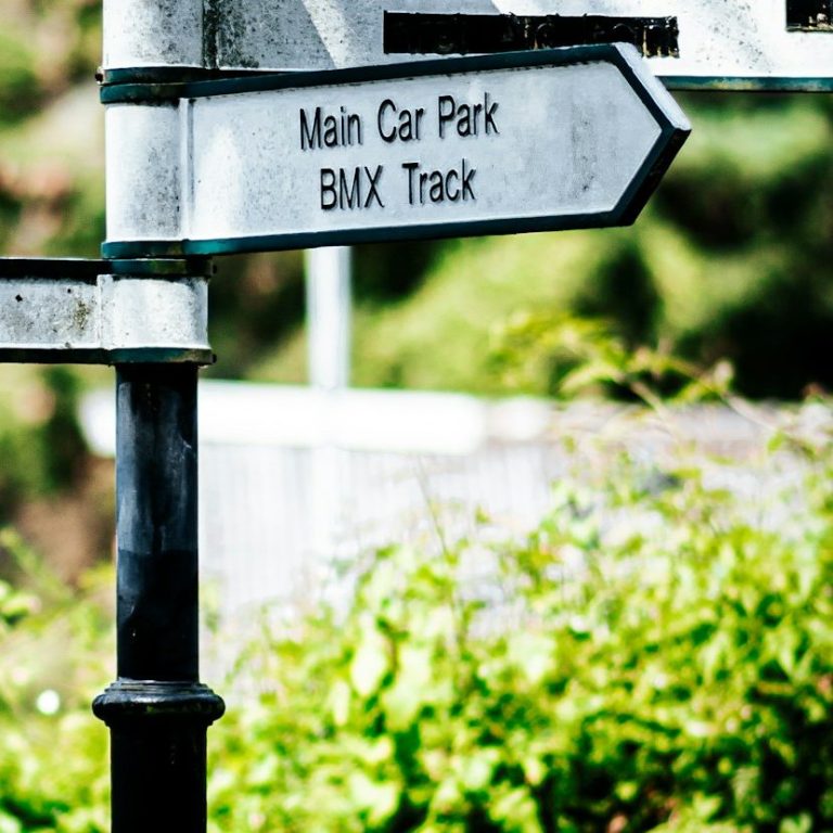 Hinweisschild mit Richtung zum Hauptparkplatz und zur BMX-Bahn.